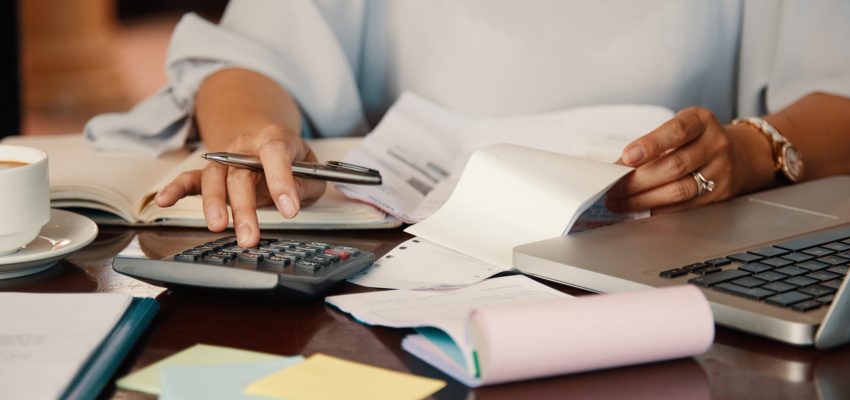 Hands of female entrepreneur working with bills and documents