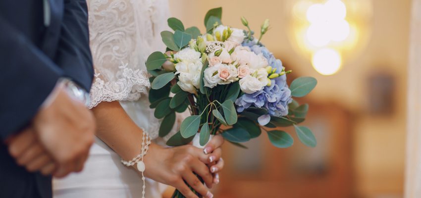 A young and beautiful bride is standing with her husband in a church